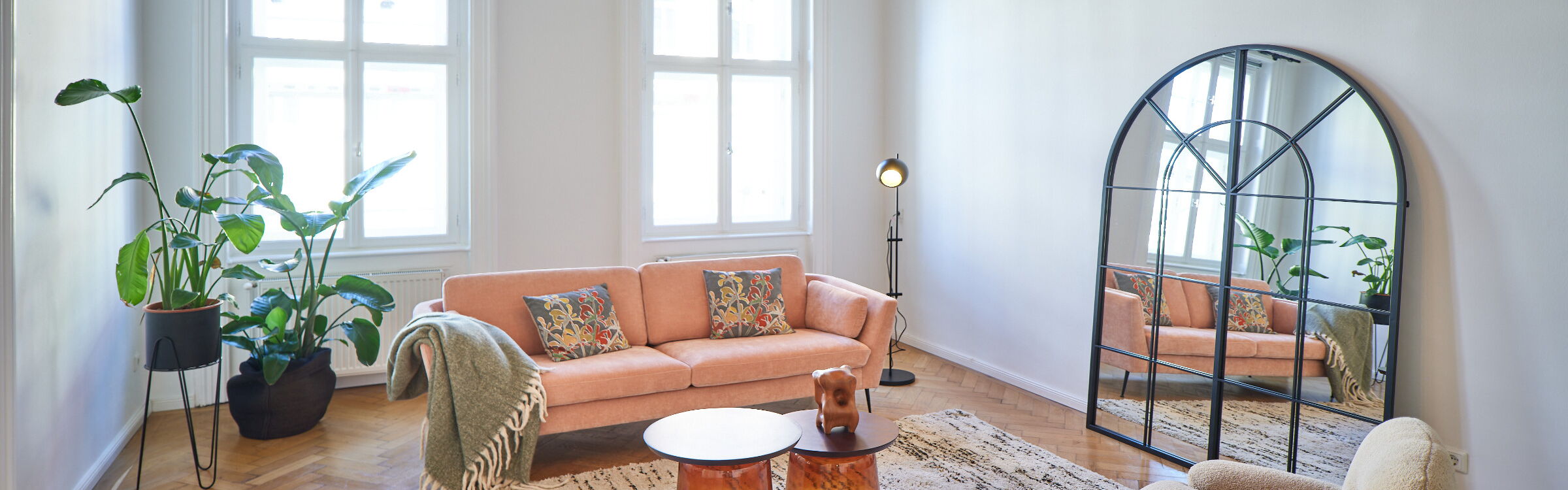 Sofa Samt apricot Couchtische braunes Glas/Holz Kuschelteppich creme Lounger in braunem Teddystoff schwarze kleine Stehleuchte großes "Fabriks-Spiegelfenster" oben oval