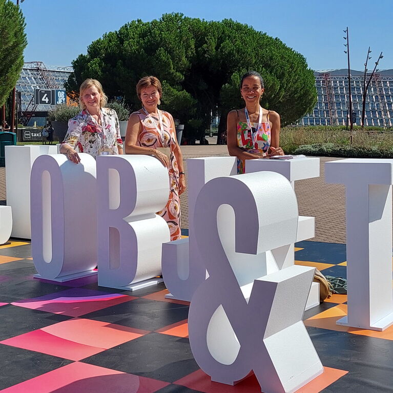Beim Messeeingang im Freien Schachbrett mit lebensgroßen Buchstaben MAISON & OBJET - dahinter die 3 WOHN.FEEn bei blauem Himmel